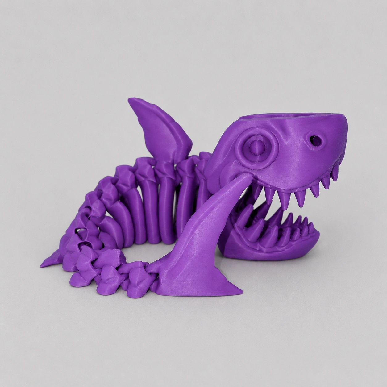 Purple 3D printed flexible shark skeleton figure.